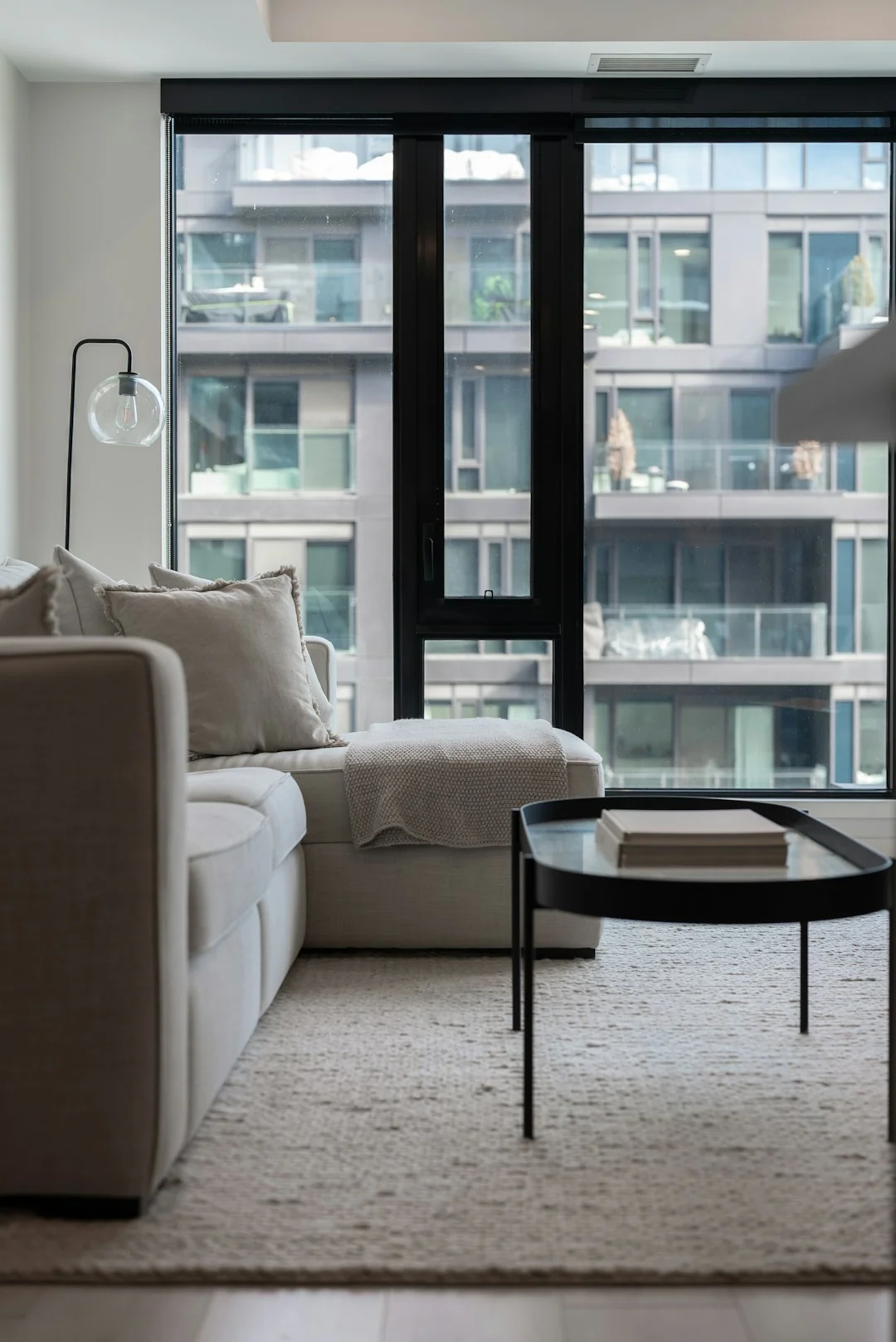 A couple tidying up their living room, organizing furniture and rugs with teamwork.